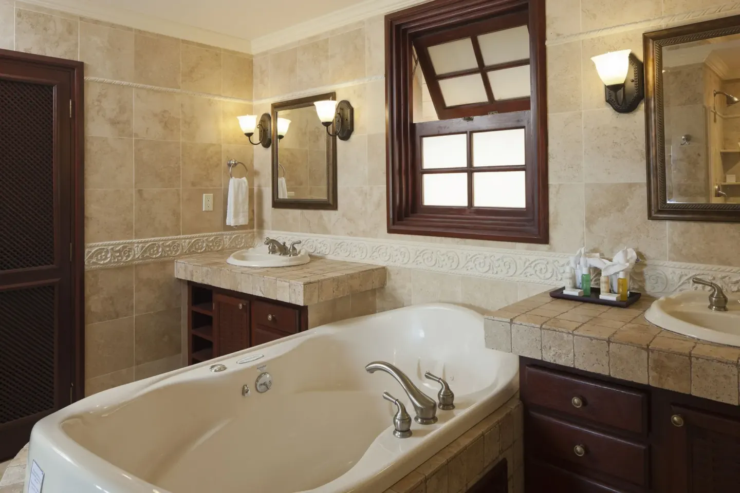 Bathroom with soaking tub, twin vanities and mirrors at The Crane Resort.