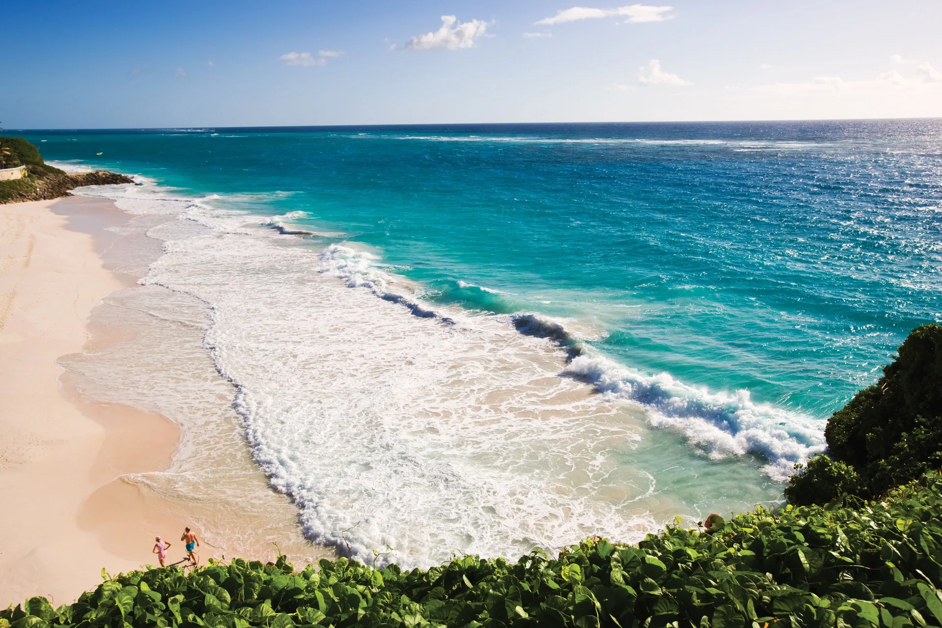 Turquoise surf rolls onto the beach below The Crane Resort.