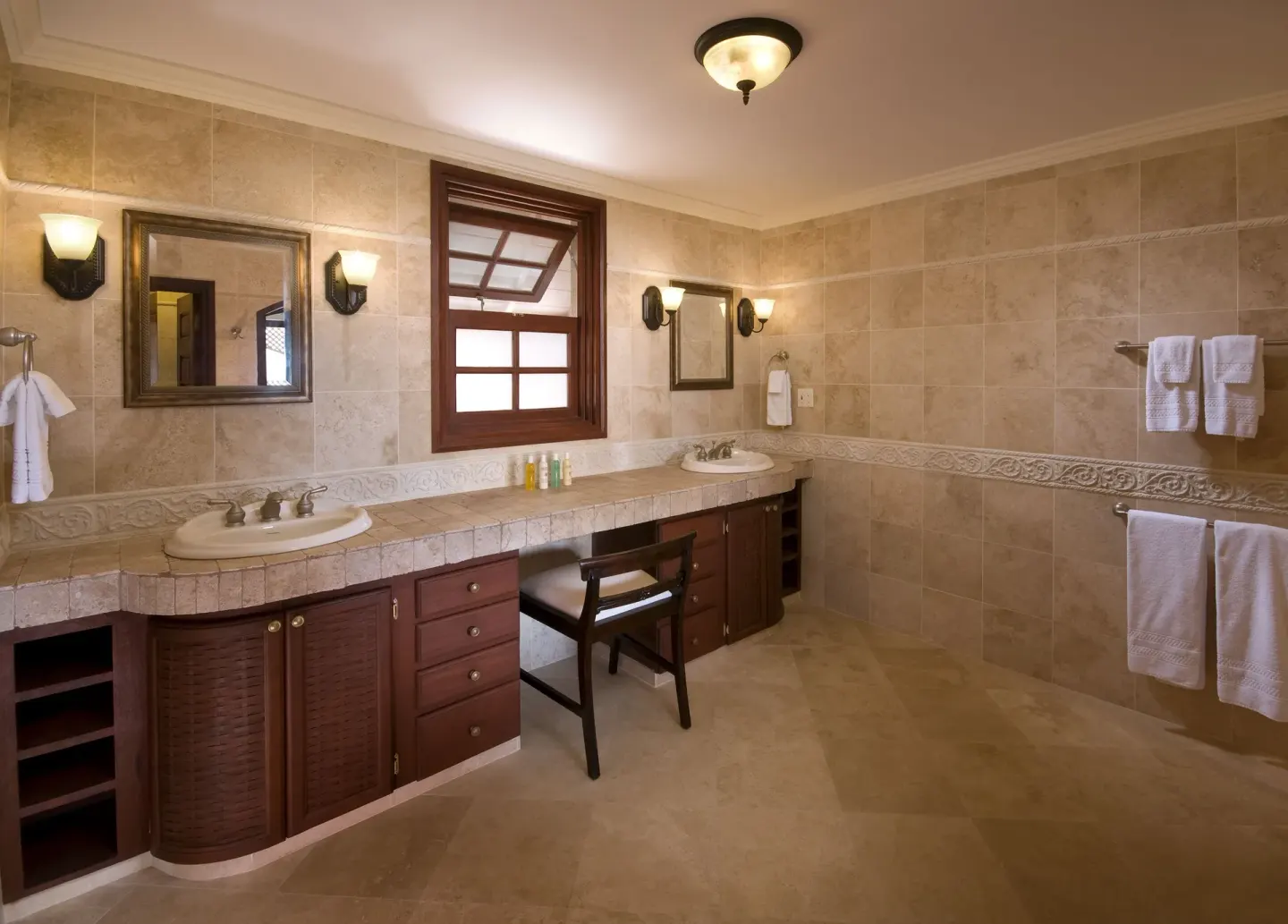 Guest bathroom with double vanity and tiled walls at The Crane Resort.