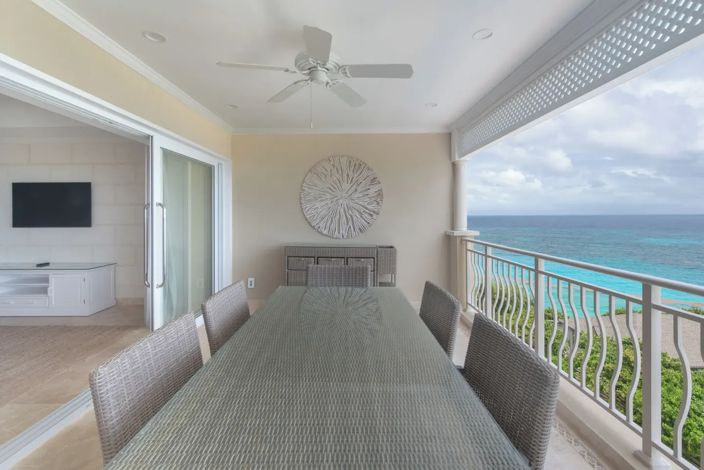 Ocean-view balcony dining table and seating at The Crane Resort.