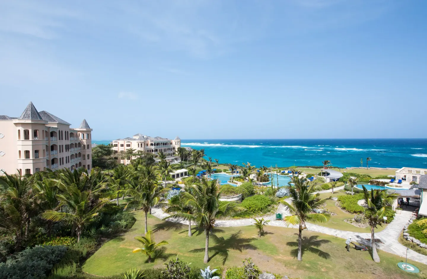 Oceanfront resort grounds with pools, palms, and buildings at The Crane Resort.