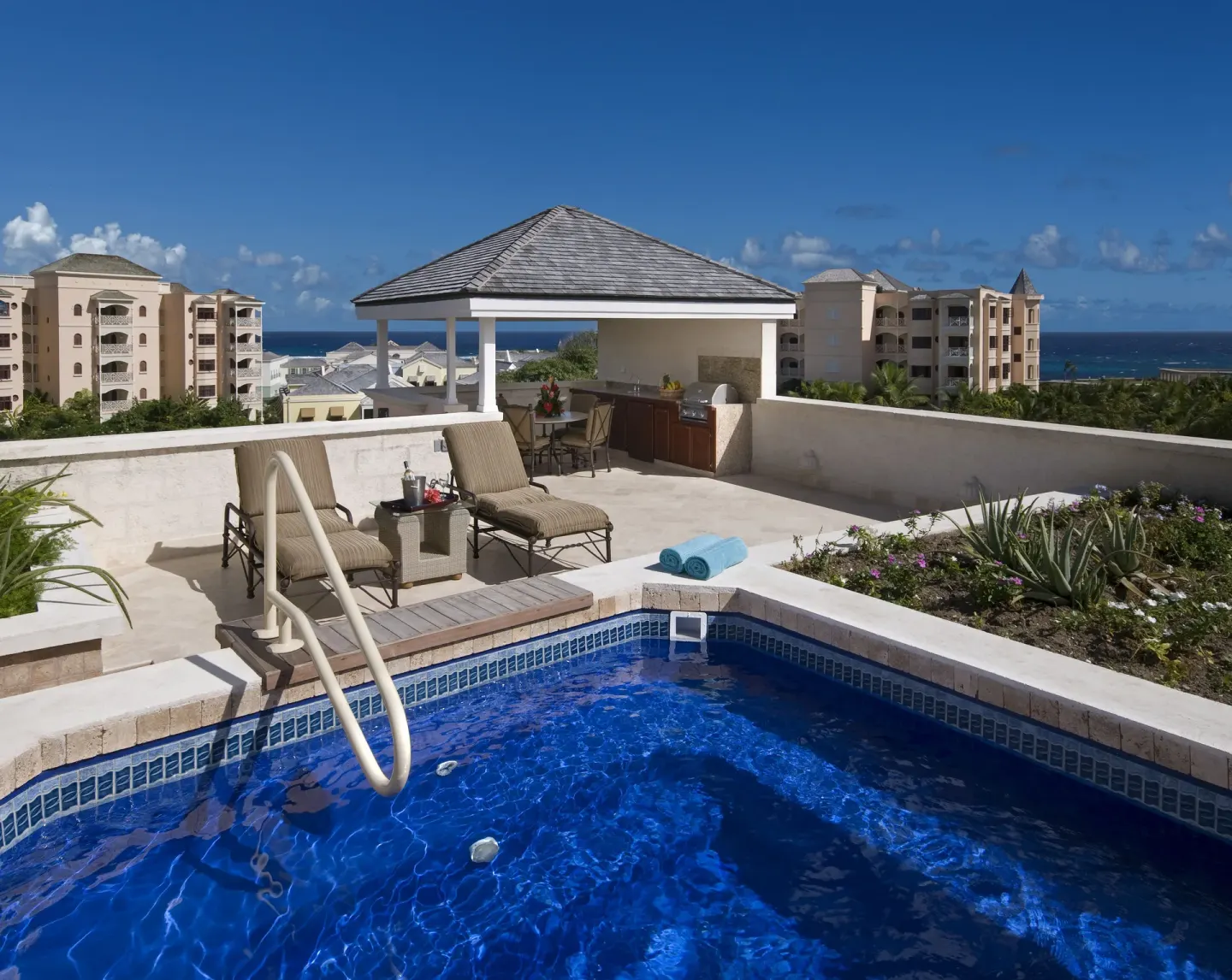 Rooftop plunge pool terrace with loungers and ocean views at The Crane Resort.