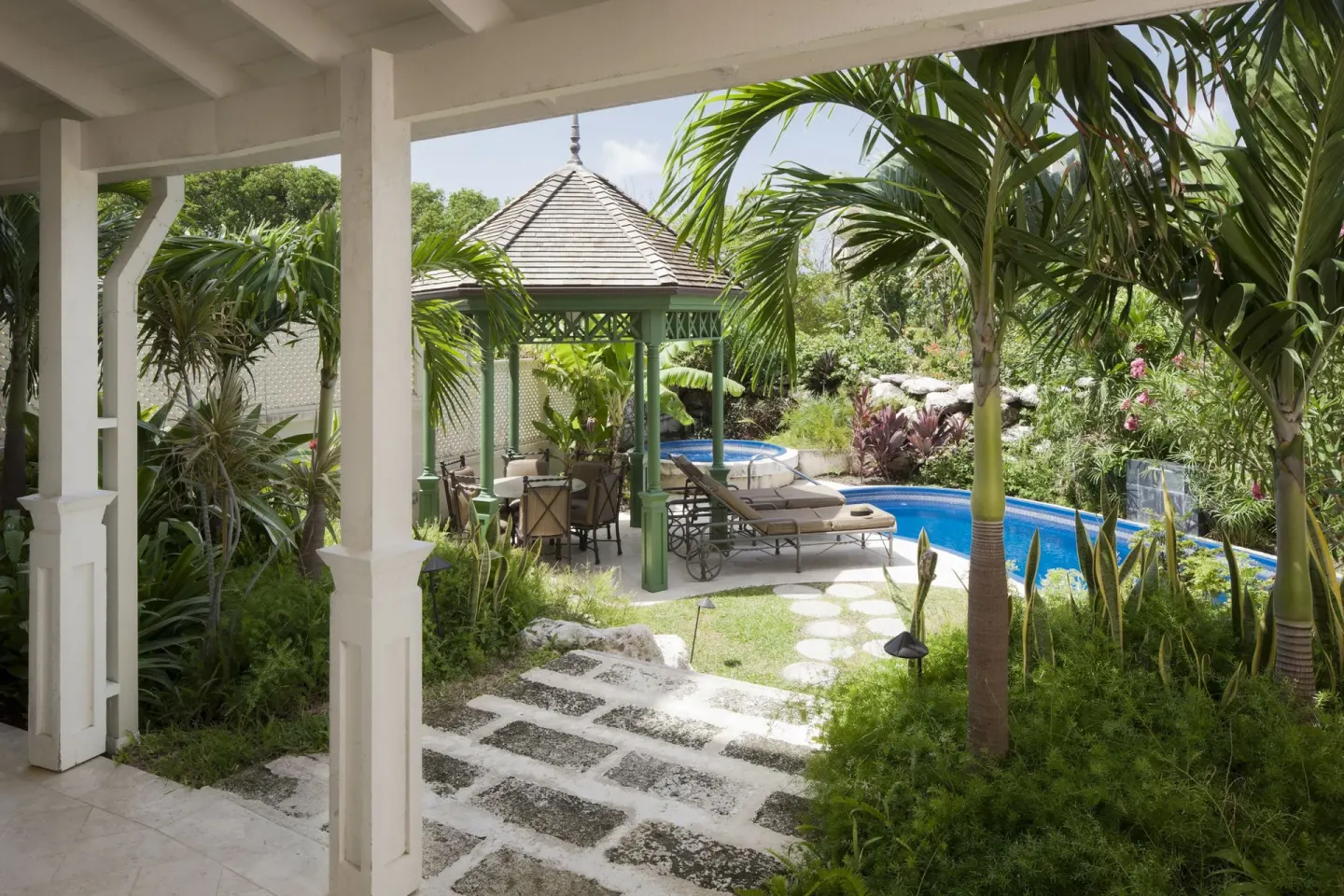 Tropical garden patio with pool, gazebo and loungers at The Crane Resort.