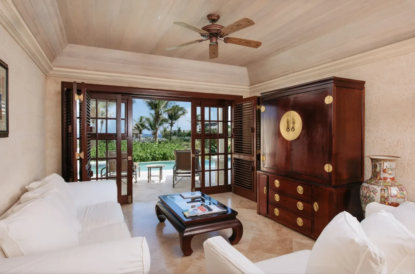 White sofas and terrace doors in a 1 Bedroom Suite with pool at The Crane Resort.