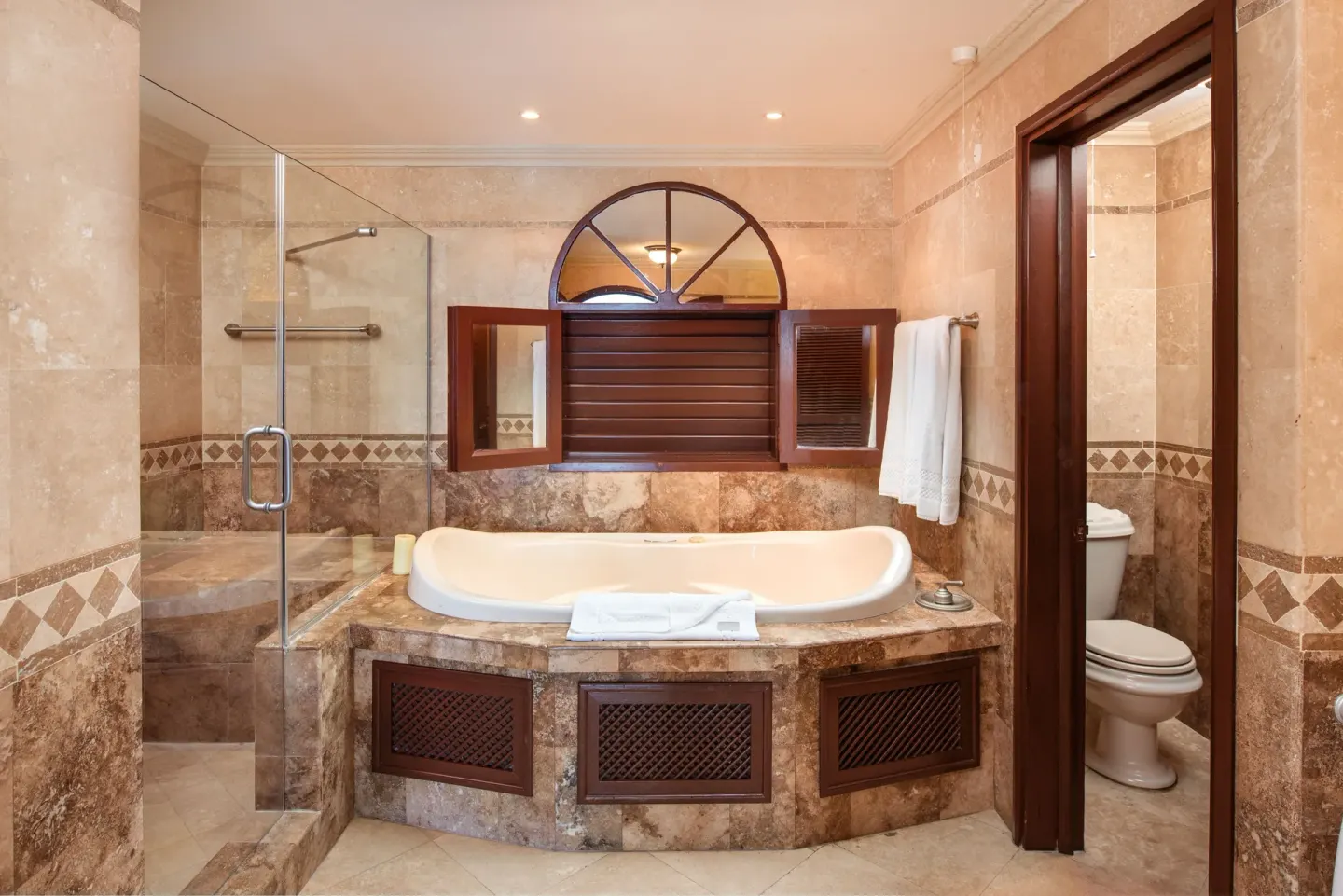 Junior Suite Garden View bathroom with soaking tub and glass shower at The Crane Resort.