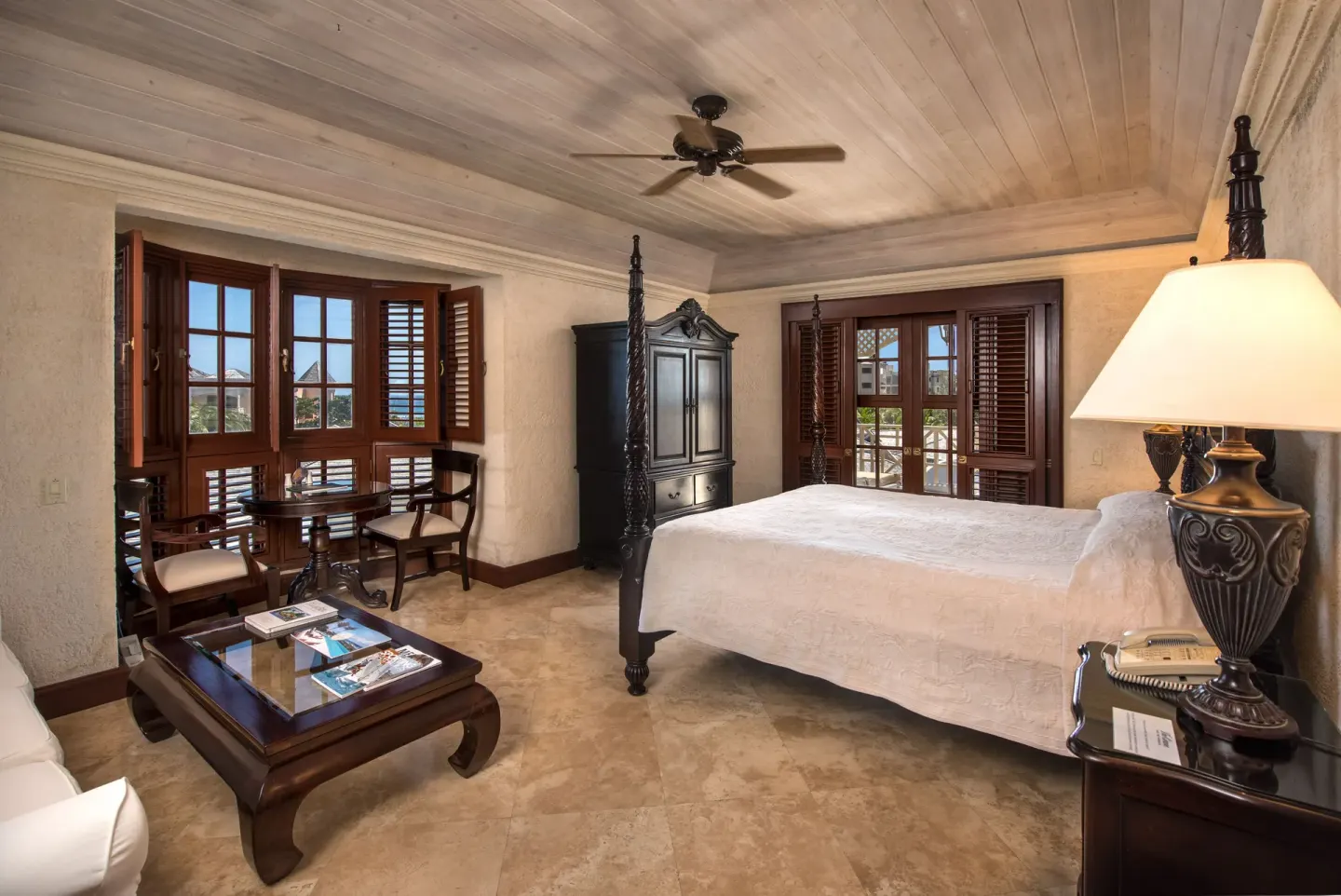 Junior Suite Garden View bedroom with four-poster bed and seating at The Crane Resort.