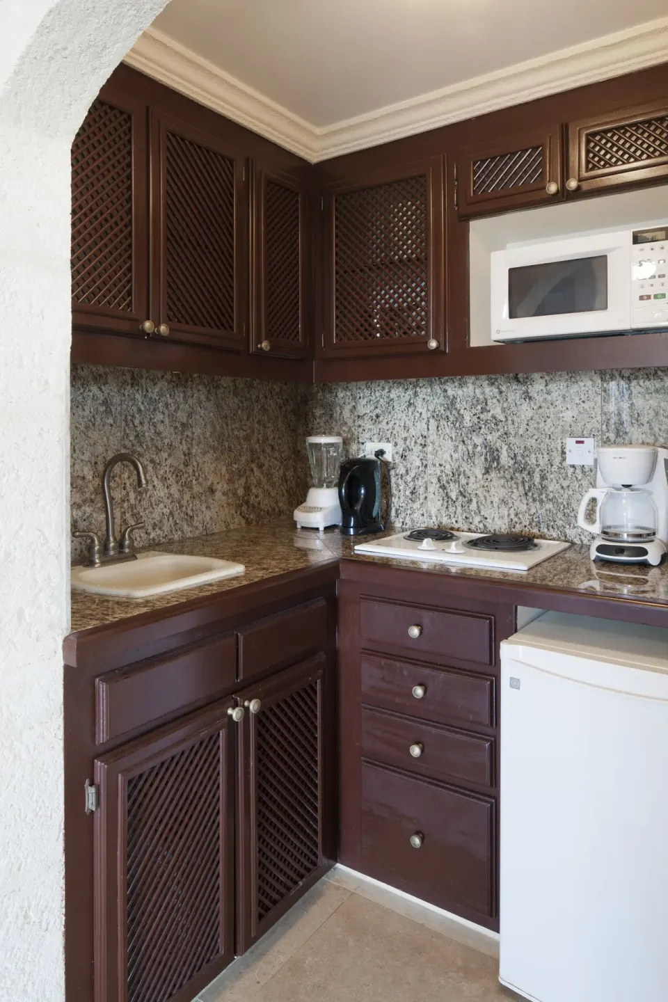 Junior Suite Garden View kitchenette with sink, cooktop, microwave and mini fridge at The Crane Resort.