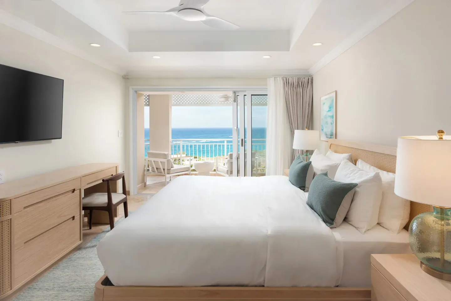 Luxury Room bedroom with king bed and ocean-facing balcony at The Crane Resort.