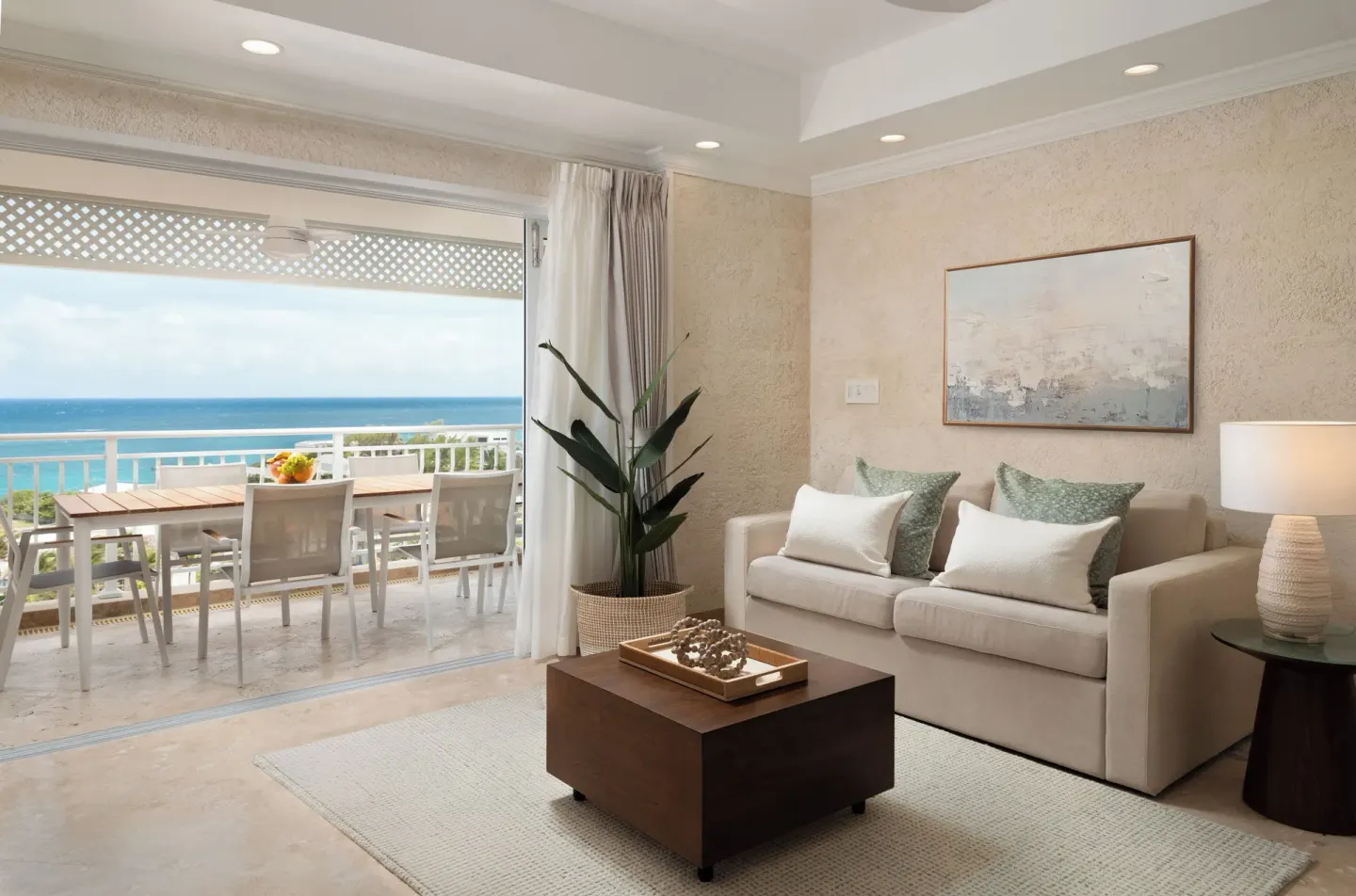 Luxury Room sitting area with sofa and balcony ocean view at The Crane Resort.