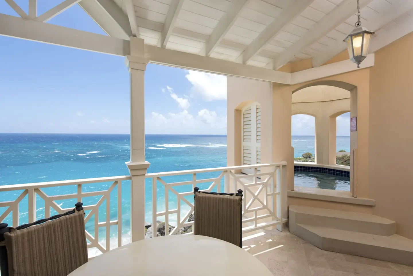 Covered balcony dining area and plunge pool with ocean view at The Crane Resort.