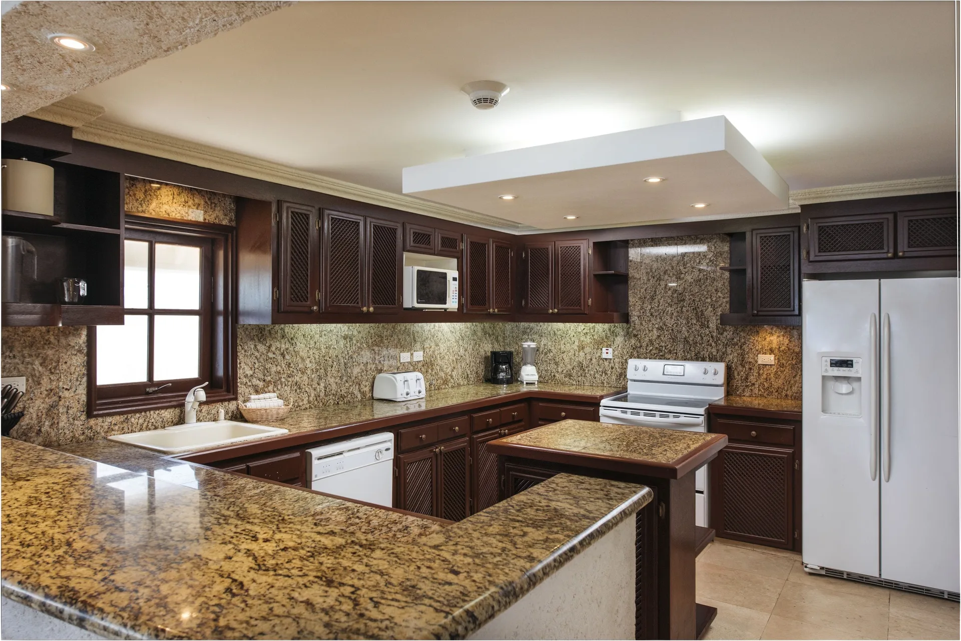 Full kitchen with granite counters in a penthouse suite at The Crane Resort.