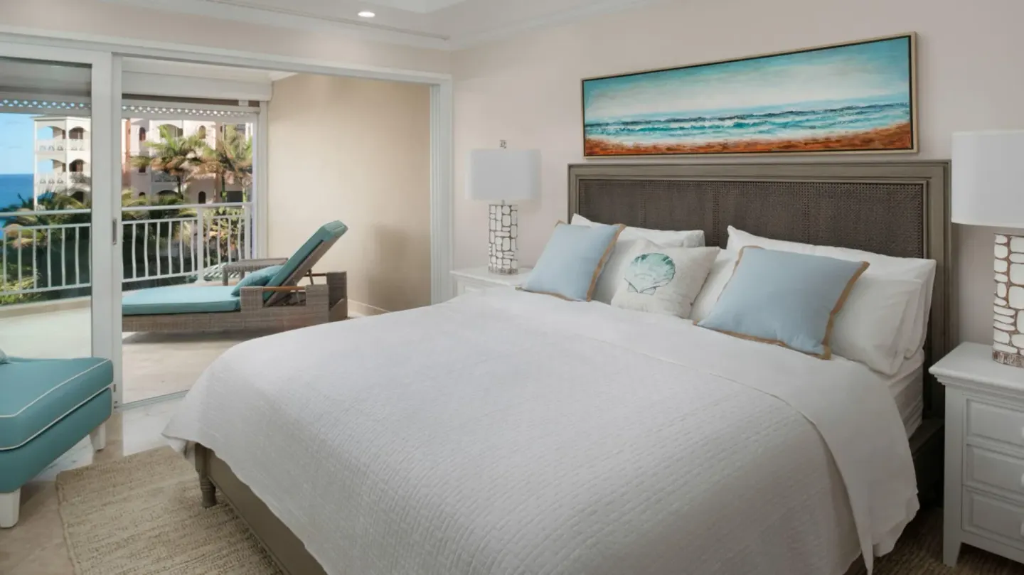 King bedroom with balcony and partial ocean view in a two-bedroom suite at The Crane Resort.