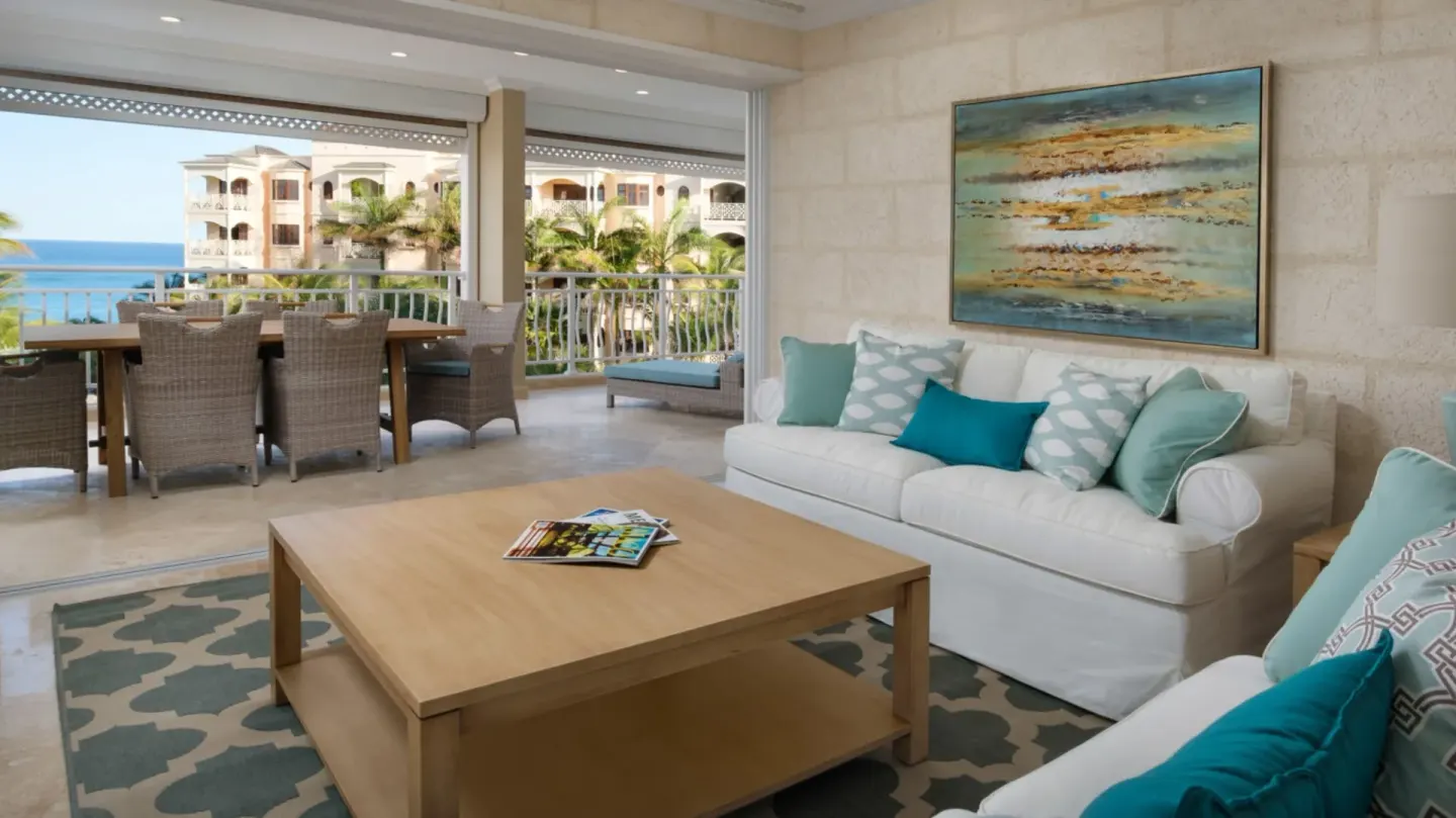 Living room and balcony with partial ocean view in a two-bedroom suite at The Crane Resort.