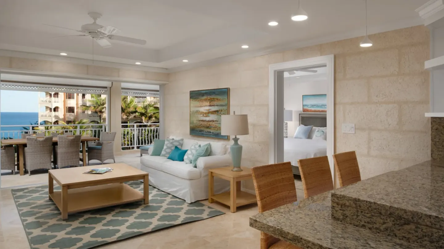 Open-plan suite living room, kitchen counter, and balcony view at The Crane Resort.