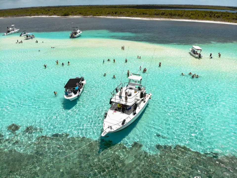 Aerial view of boats anchored at a shallow sandbar near The Explorean Cozumel.