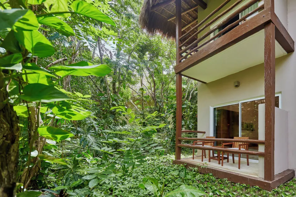Grounds view of a two-level room balcony surrounded by dense jungle foliage at The Explorean Cozumel
