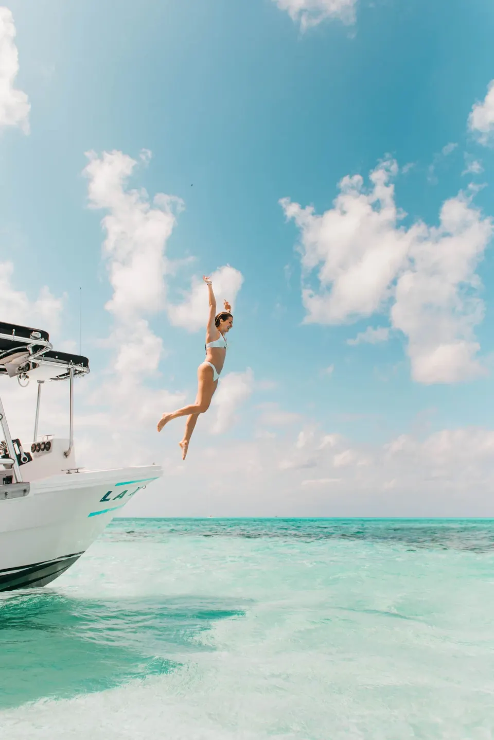Guest jumping from a boat into clear turquoise water at The Explorean Cozumel.
