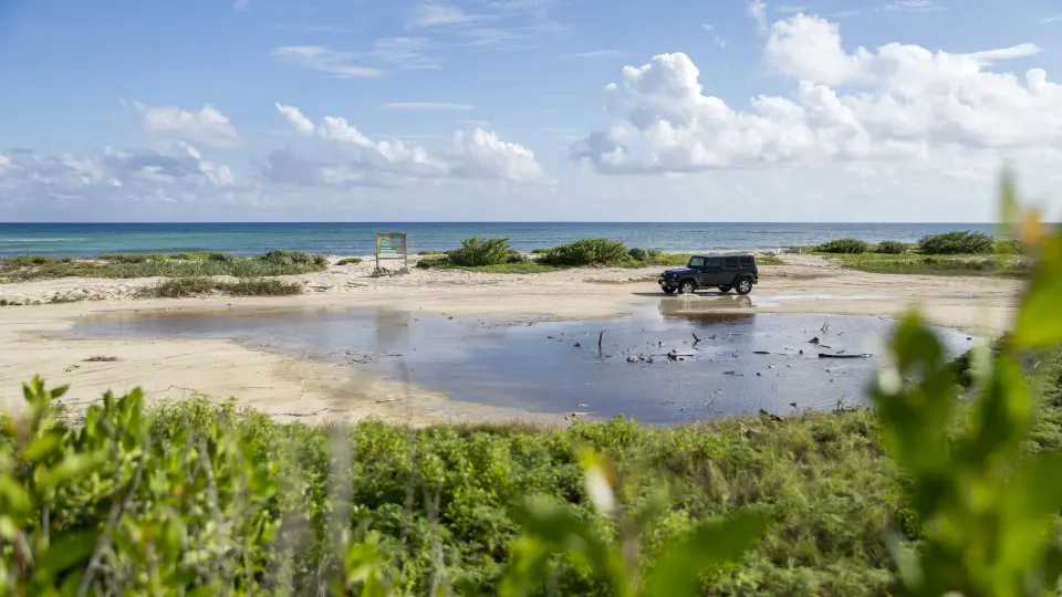 Jeep parked near a coastal lagoon with the ocean beyond at The Explorean Cozumel
