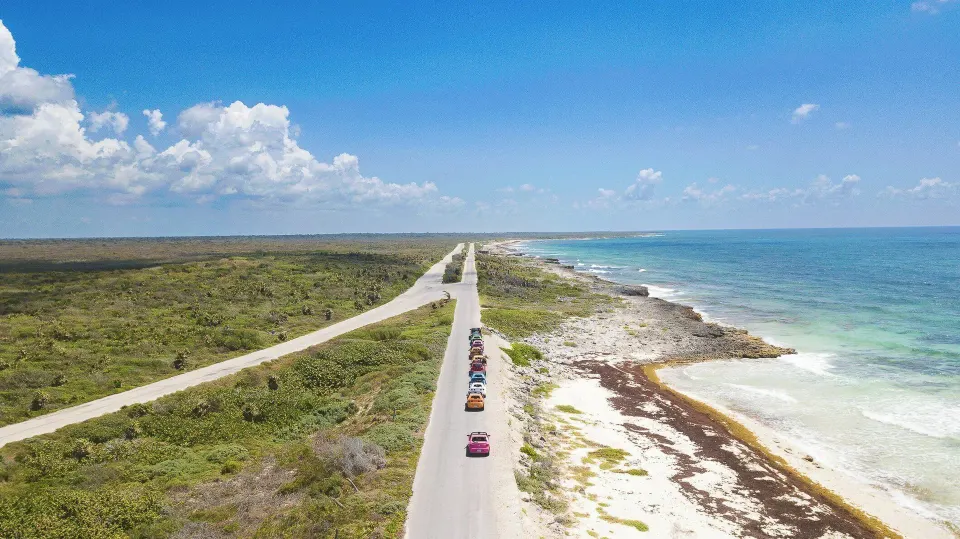 Coastal road and vehicles along the shoreline near The Explorean Cozumel