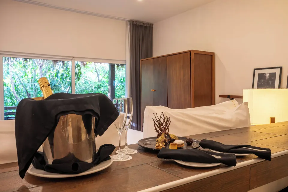 Champagne bucket and plated desserts on a dresser in a guest room at The Explorean Cozumel