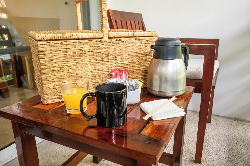 Close-up of coffee, orange juice and wicker basket on a table in a room at The Explorean Cozumel