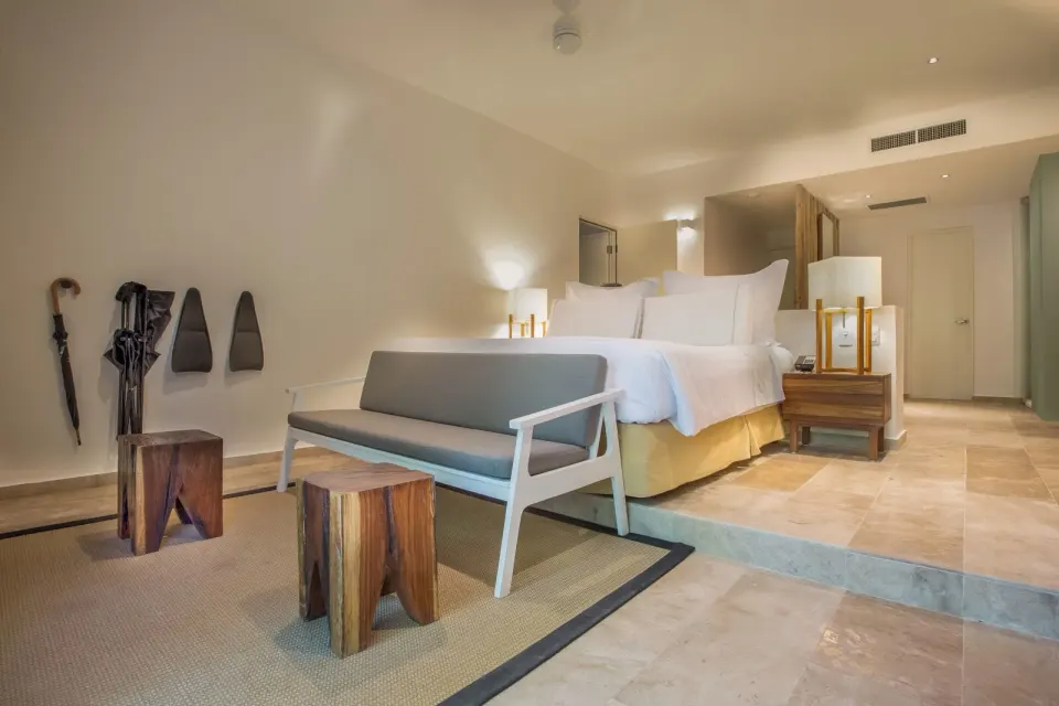 King bed and seating bench in a guest room at The Explorean Cozumel