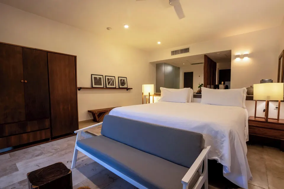 King bed with wardrobe and wooden furniture in a guest room at The Explorean Cozumel