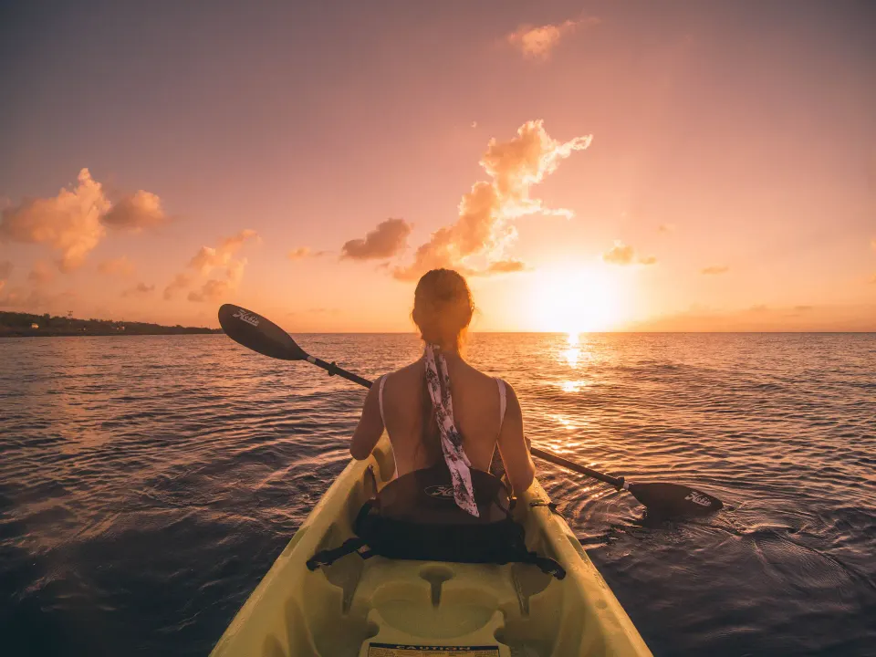 Guest kayaking toward a colorful sunset at The Explorean Cozumel.