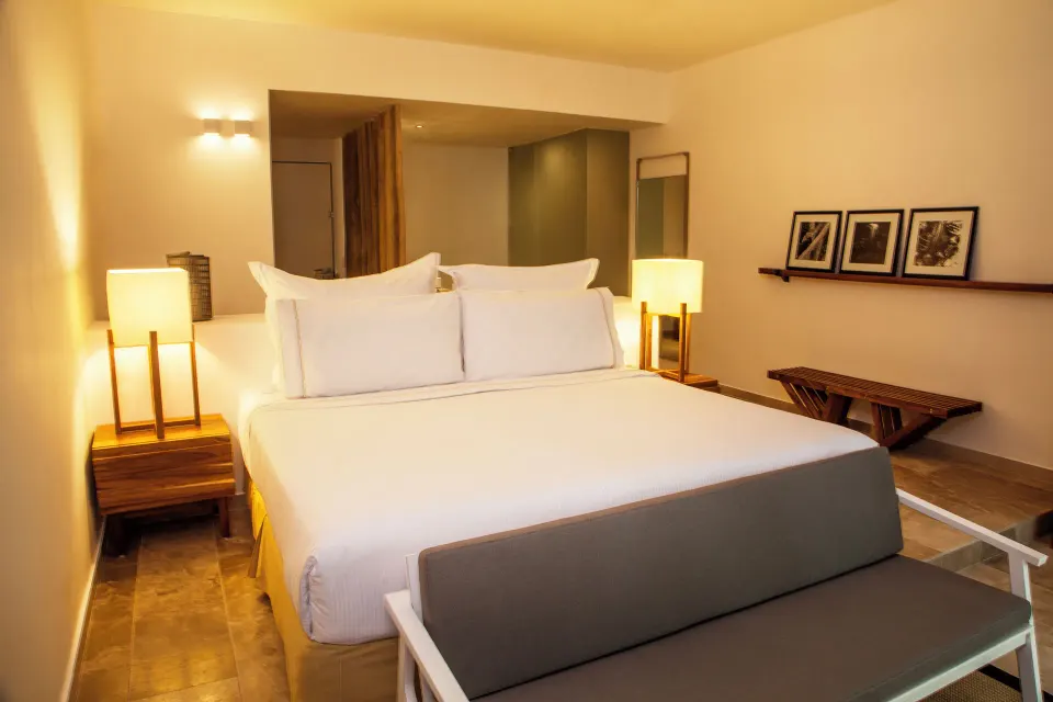 Close view of a king bed with bedside tables and lamps at The Explorean Cozumel