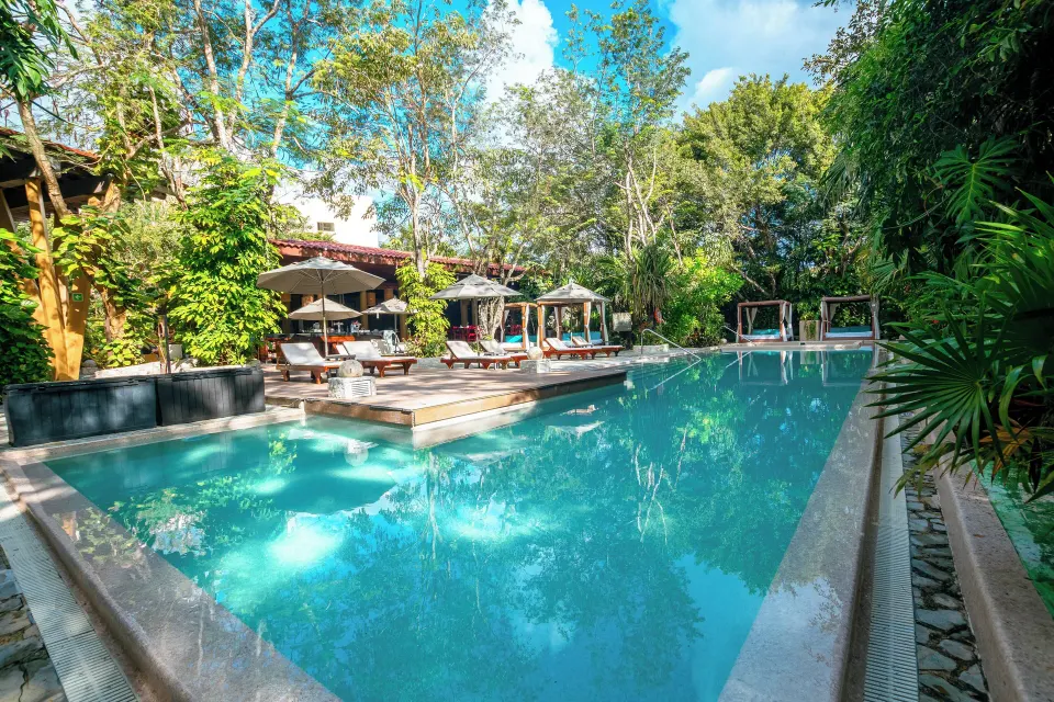 Outdoor resort pool with sun loungers and cabanas at The Explorean Cozumel