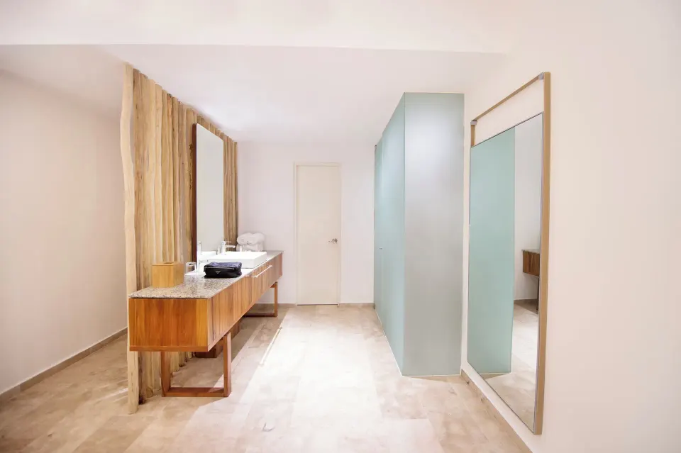 Bright minimal resort bathroom vanity and large mirror at The Explorean Cozumel