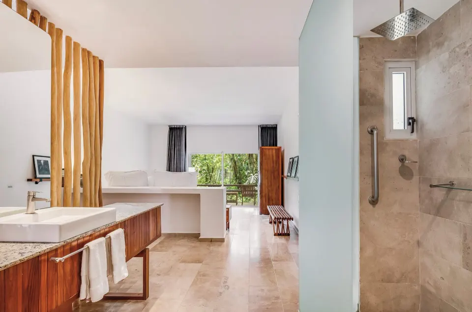 Open suite view from bathroom through to balcony and greenery at The Explorean Cozumel