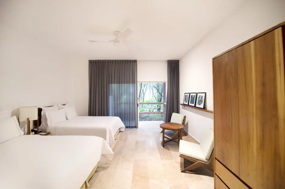 Spacious twin room with two beds and balcony door at The Explorean Cozumel