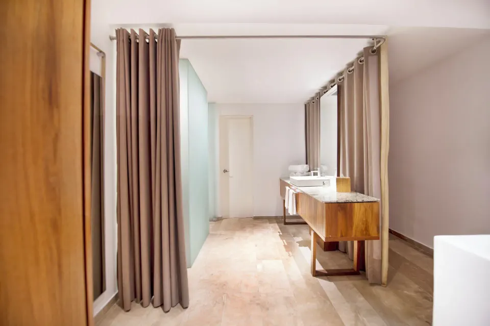 Casita Stand Alone bathroom vanity area with double sinks and privacy curtains at The Explorean Cozumel.