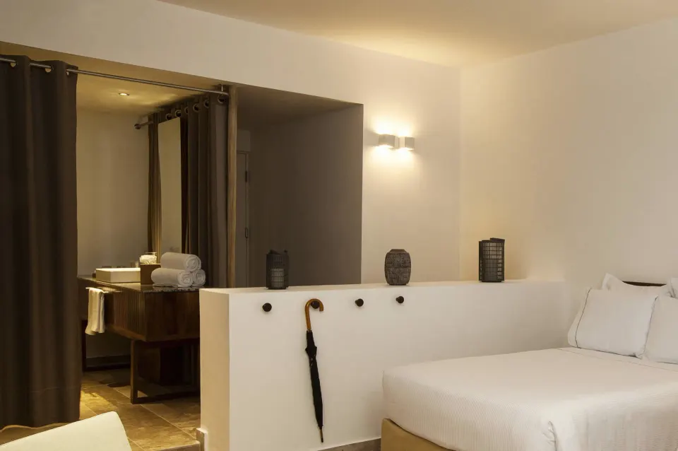 Casita Stand Alone low wall separating bed area from bathroom with umbrella hung at The Explorean Cozumel.