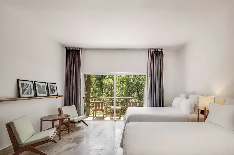 Bright Casita Stand Alone room with two beds and sliding glass doors at The Explorean Cozumel.