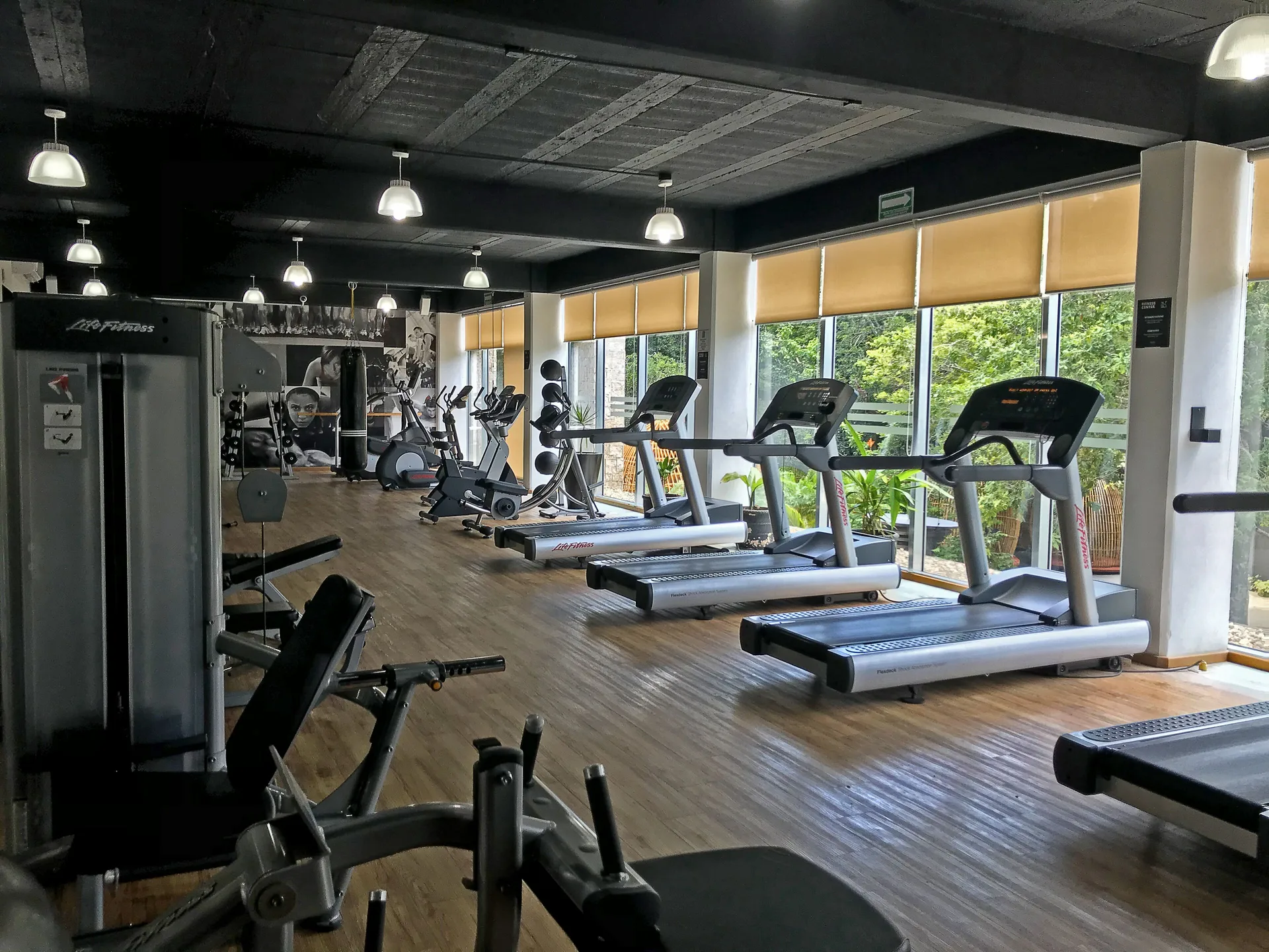 Treadmills and weight machines line the fitness center at The Fives Beach Hotel.