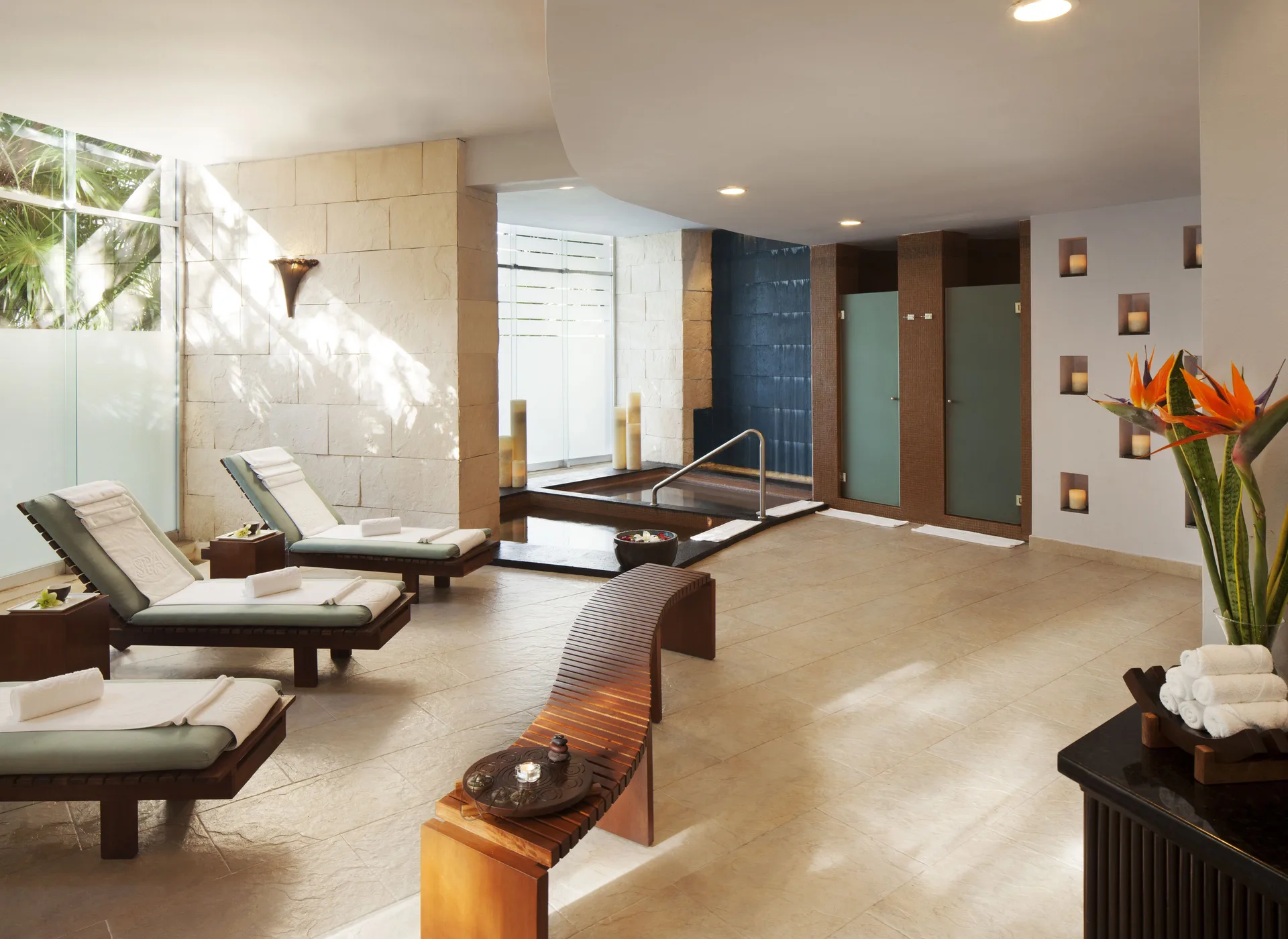 Spa lounge chairs and a small pool sit in a quiet relaxation area at The Fives Beach Hotel.