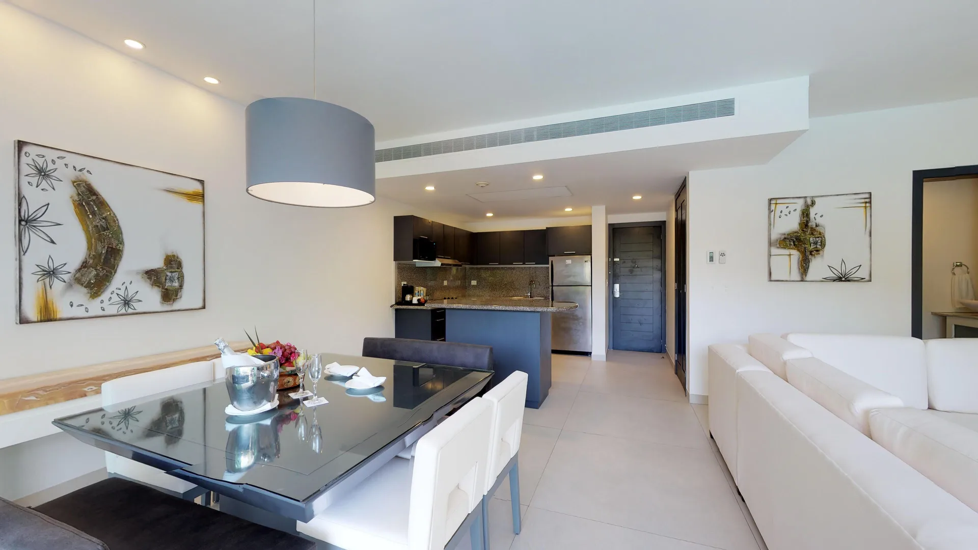 Suite dining area, kitchenette, and white sofa at The Fives Beach Hotel.