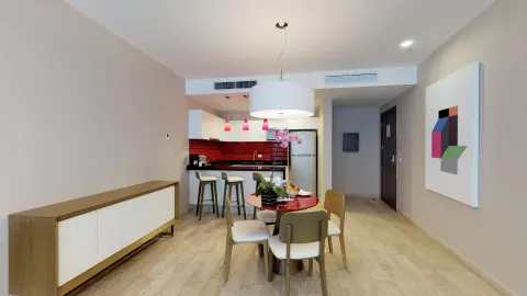 Suite dining area with red-accent kitchenette at The Fives Beach Hotel.