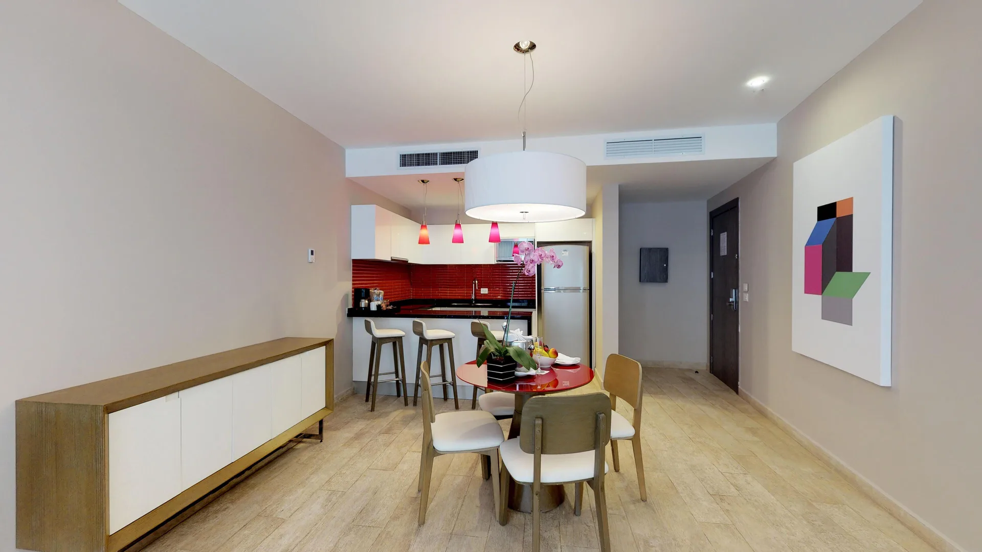 Suite dining area with red-accent kitchenette at The Fives Beach Hotel.