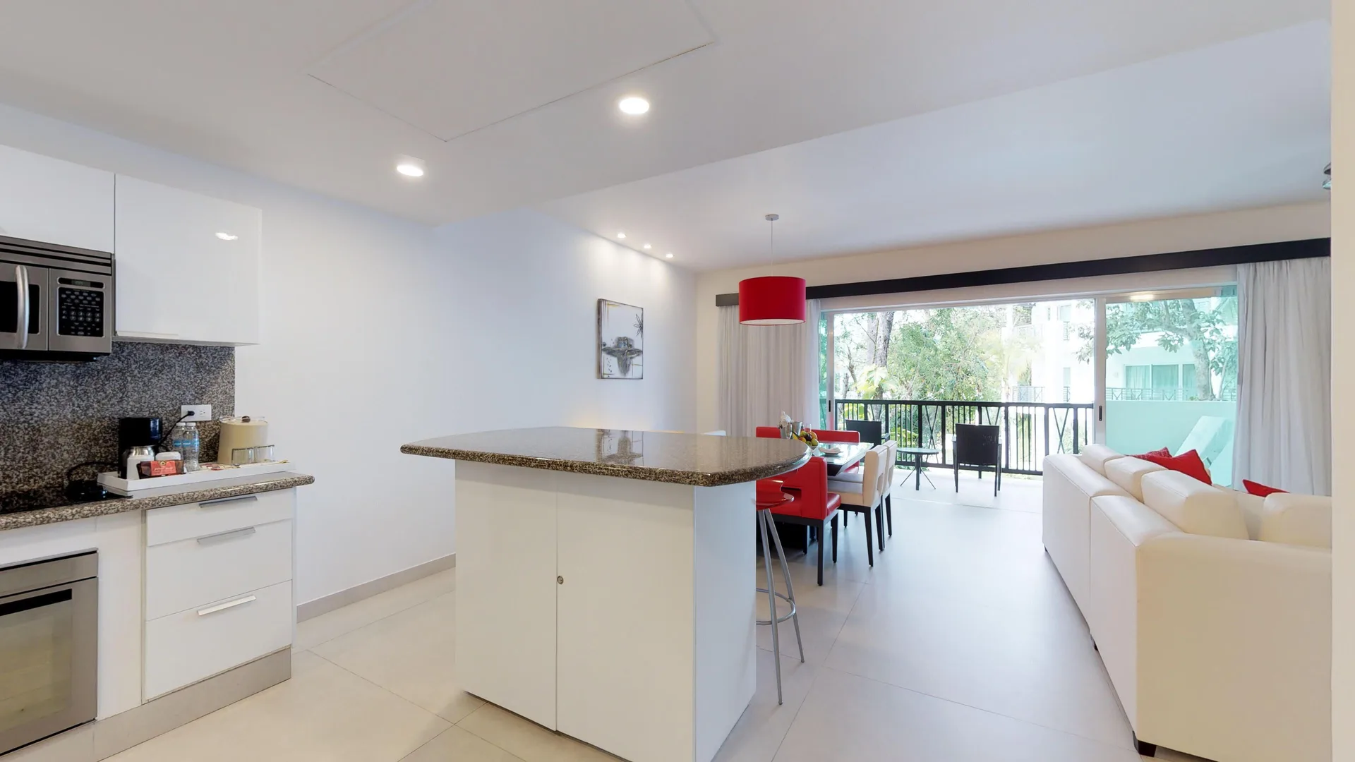 Suite kitchen and living area with balcony beyond at The Fives Beach Hotel.