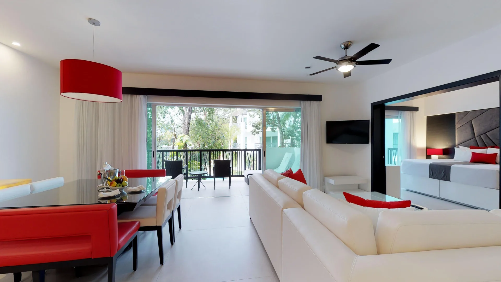 Suite living area with king bed visible and balcony at The Fives Beach Hotel.