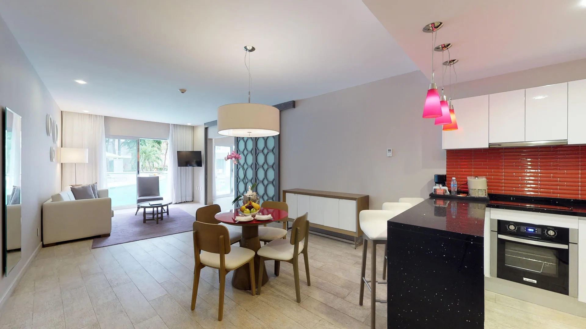 Suite living area with kitchenette, dining table, and sofa at The Fives Beach Hotel.