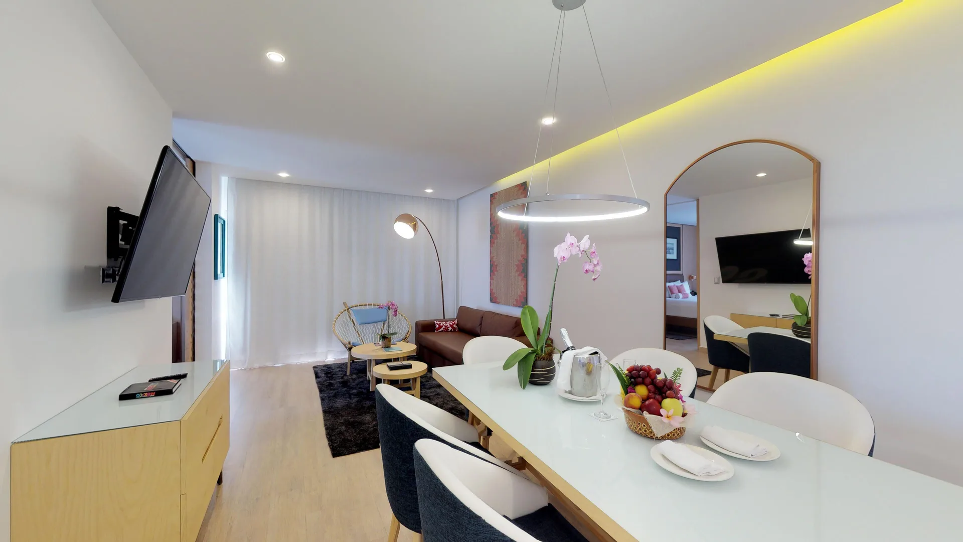 Suite living and dining area with sofa and table at The Fives Beach Hotel.