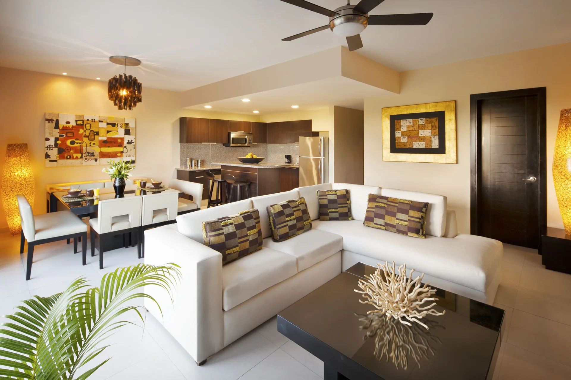 Suite living room with sectional sofa and kitchen at The Fives Beach Hotel.