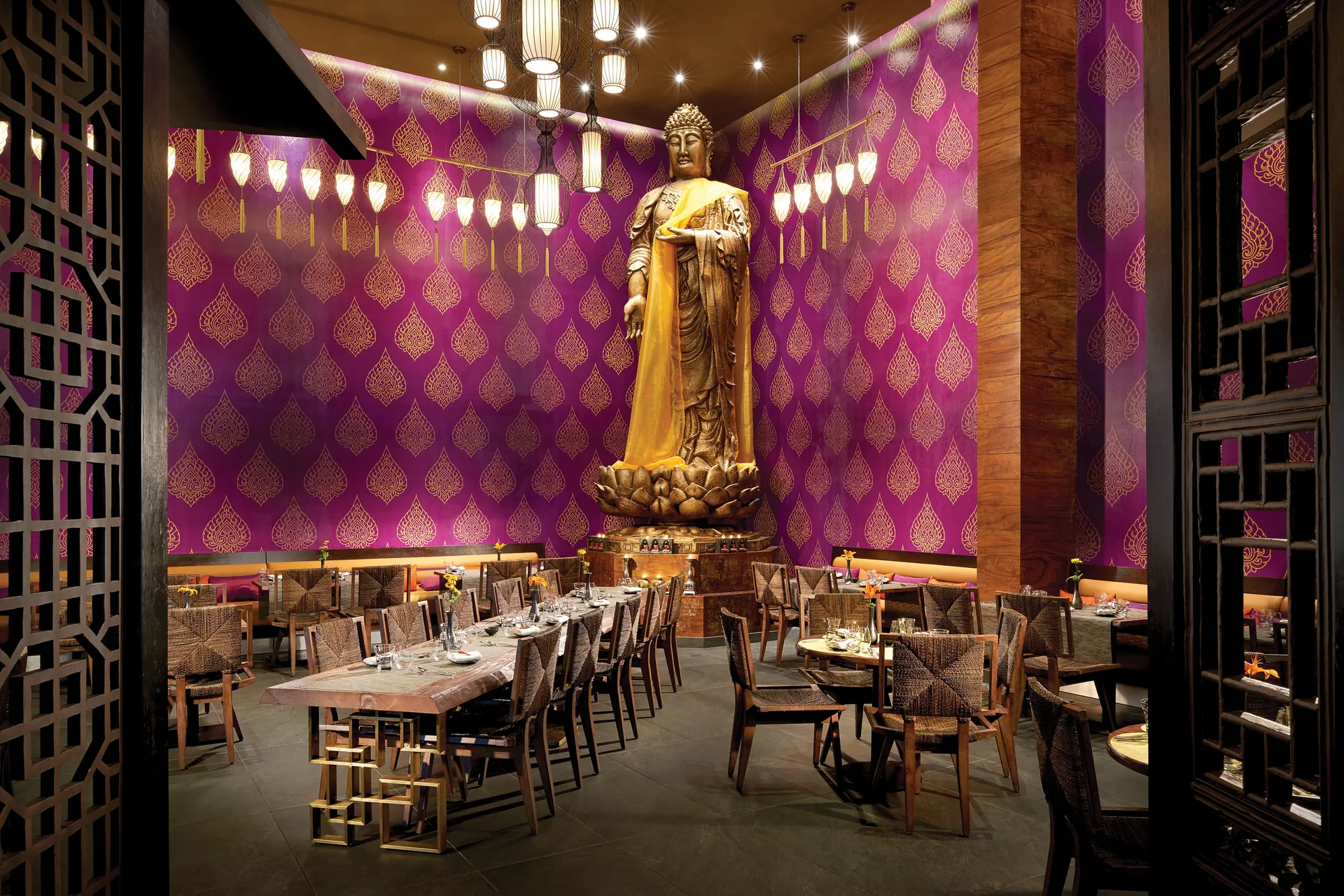 Thai-style dining room with a large Buddha statue at The Fives Beach Hotel.