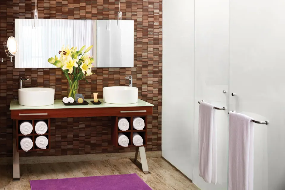 Deluxe Room bathroom with double vessel sinks and towels at The Fives Beach Hotel.