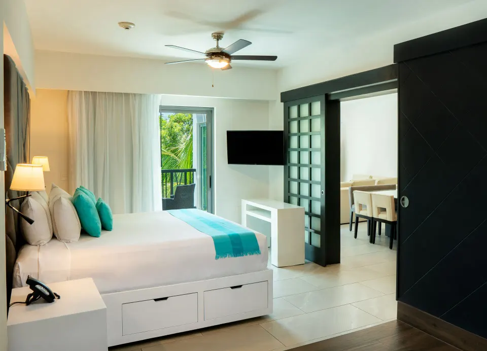 One Bedroom Penthouse Suite bedroom with king bed and balcony at The Fives Beach Hotel.