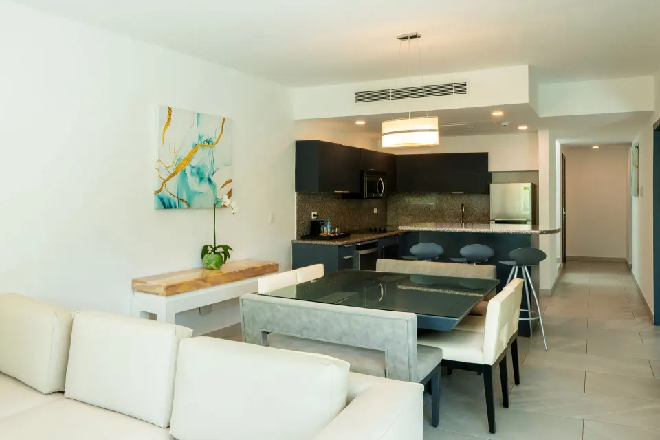One Bedroom Penthouse Suite living area with kitchen and dining table at The Fives Beach Hotel.